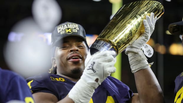 Michigan defensive lineman Kris Jenkins (94) picks up the trophy to celebrate the Wolverines' 34-13 win over Washington at the national championship game at NRG Stadium in Houston on Monday, Jan. 8, 2024.